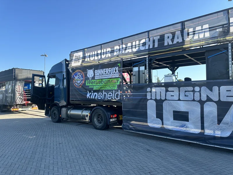 DJ-Truck mit großflächigem Branding für eine Techno-Parade