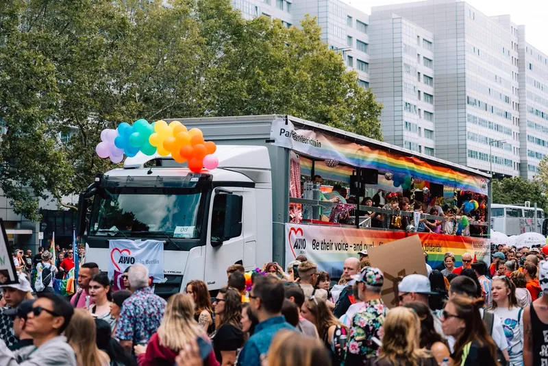 Paradetruck mit Regenbogen-Ballons und Gruppe auf der Ladefläche